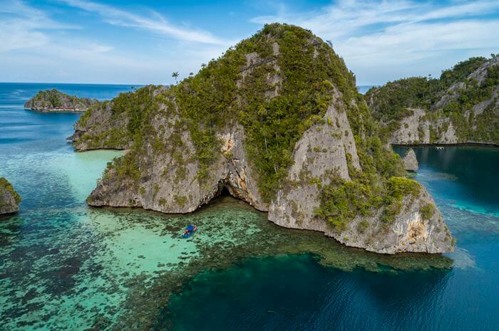 Perairan Misool yang berlokasi di Raja Ampat memiliki bebatuan tinggi menyerupai tebing, pasir putih hangat, dan laut hijau tosca jernih